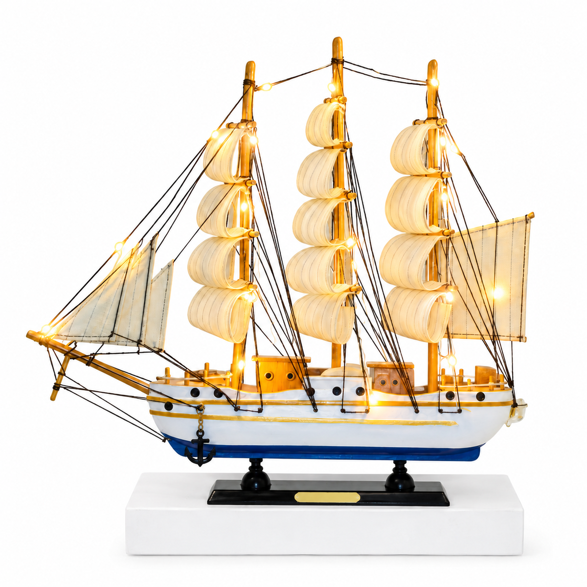 A lit wooden sailing ship model with illuminated white sails, gold-toned rigging and masts, a blue hull, and a black display base on a white pedestal against a light gray background.